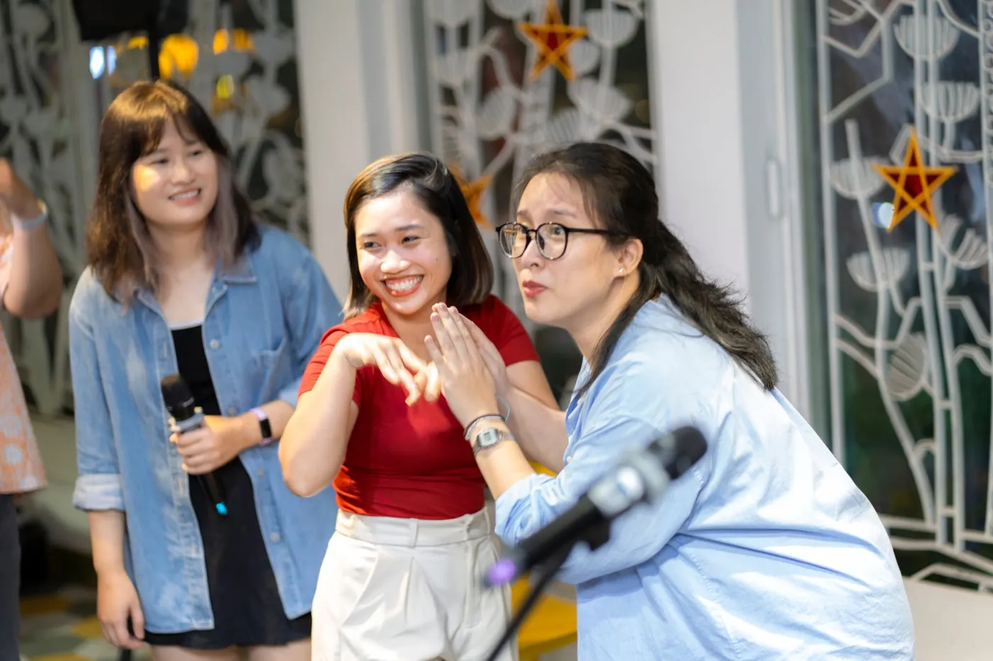 Ba diễn viên chơi game ứng tác với micro trên sân khấu