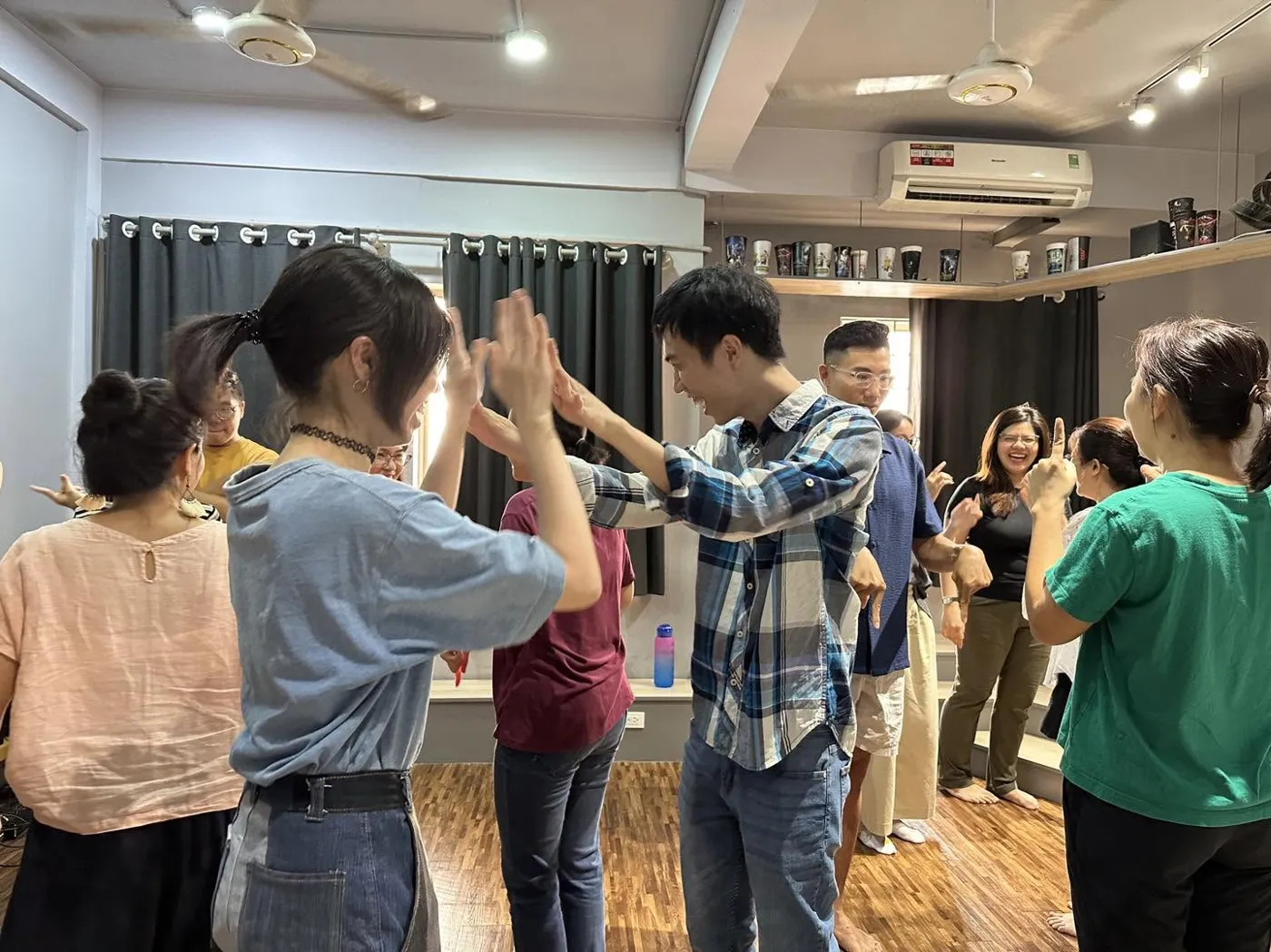Học viên chạm tay nhau trong một bài tập chuyển động của lớp kịch ứng tác