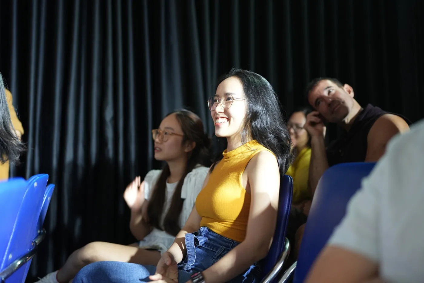 Khán giả chăm chú theo dõi và mỉm cười trong một show ứng tác tiếng Anh