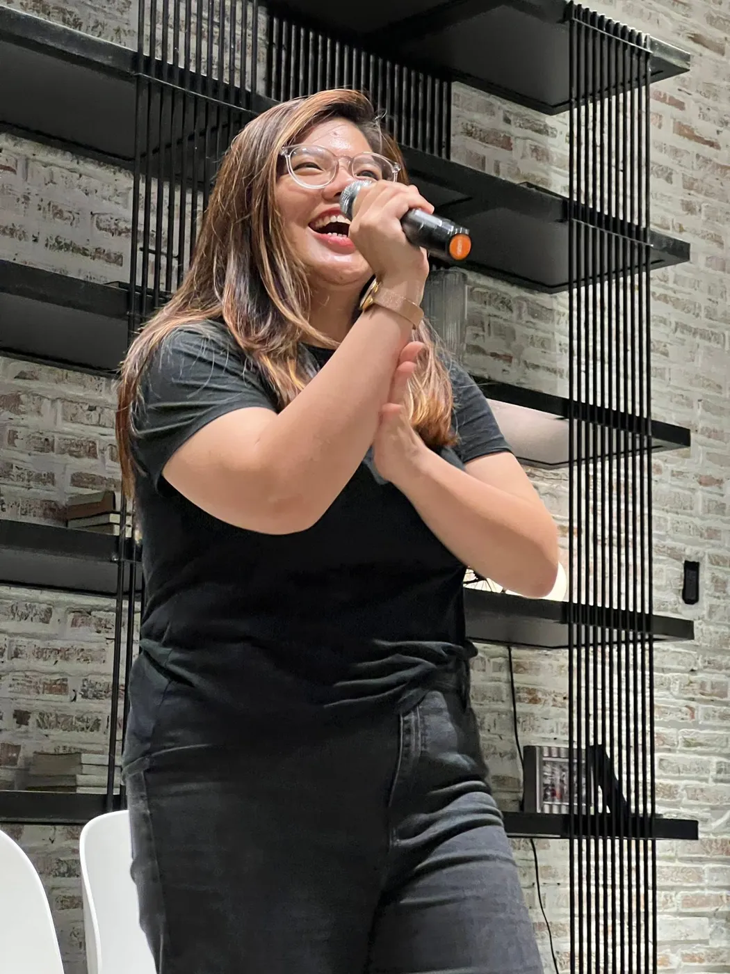 Diễn viên ứng tác cười rạng rỡ cầm micro trong show của Saigon Improv House