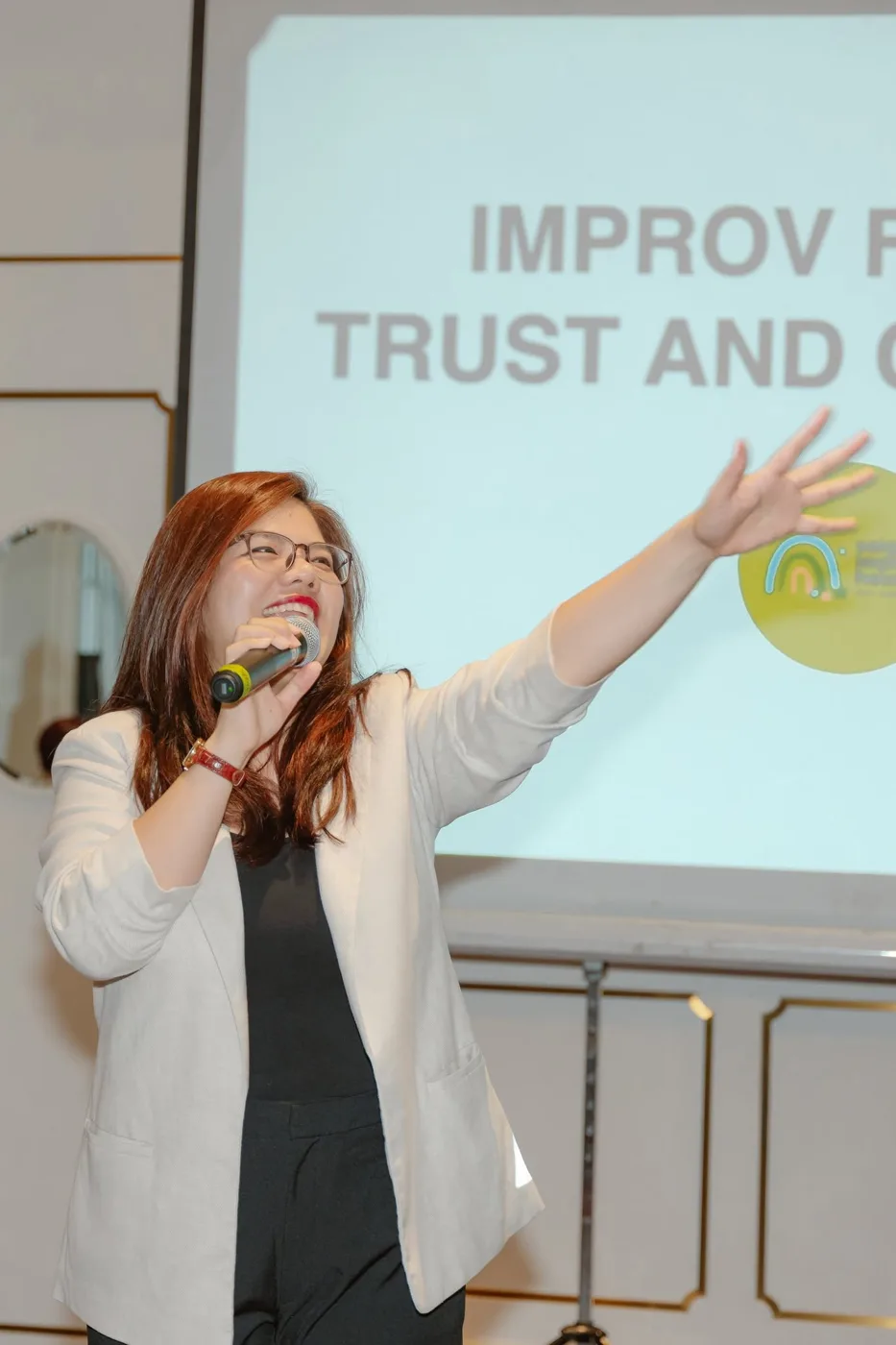Vân Possible cầm micro chia sẻ trước màn chiếu Improv trong một workshop ứng tác