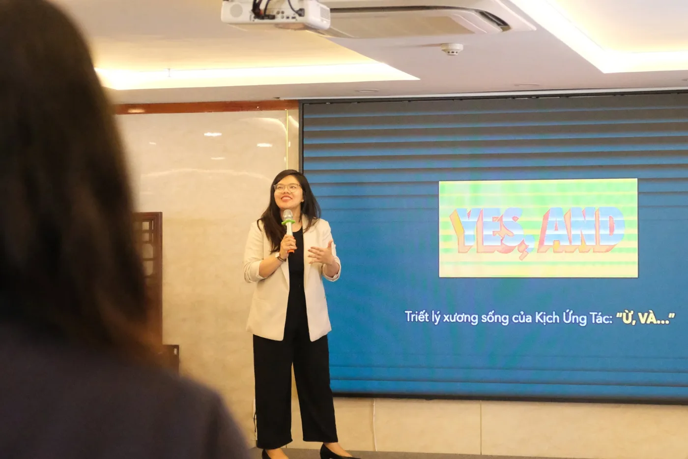 Vân Possible giảng triết lý Yes, and trước màn chiếu trong một workshop kịch ứng tác