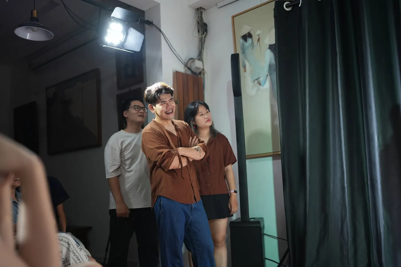 Học viên kịch ứng tác khoanh tay cười rạng rỡ dưới ánh đèn sân khấu