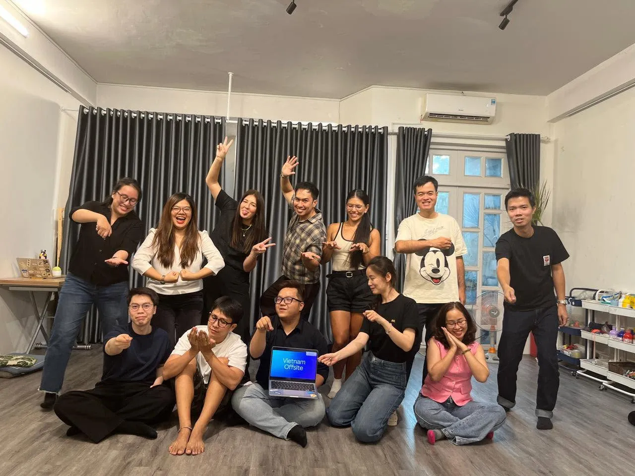 Nhóm người tham gia workshop tạo dáng vui nhộn bên laptop hiện chữ Vietnam Offsite